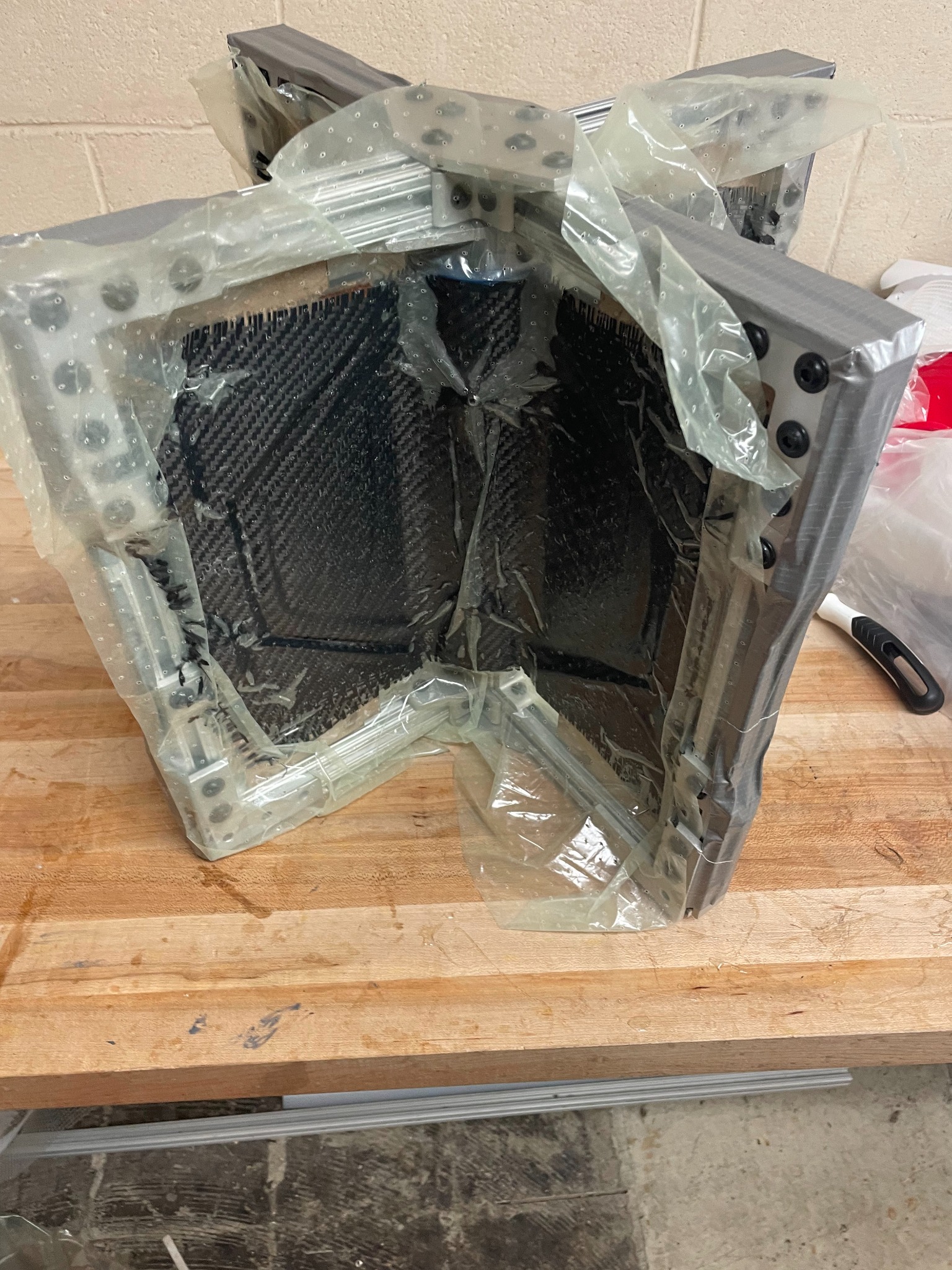 Unsuccessful vacuum bagging attempt around carbon fiber fin tooling